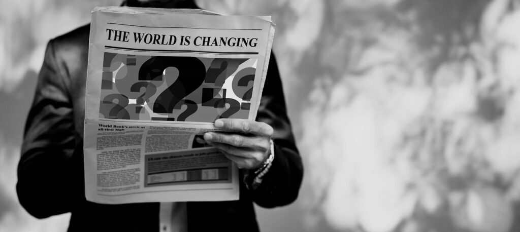 Un journal en noir et blanc avec le titre The world is changing et de gros points d'interrogation en dessous. 