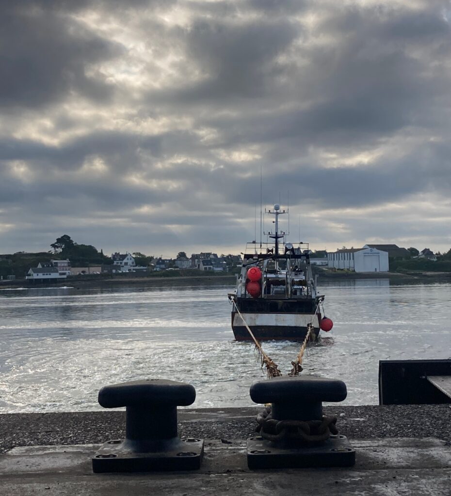 Un bateau de peche à quai sous un ciel gris